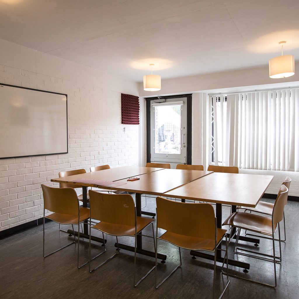 Meeting room with square table set for a meeting for 8.