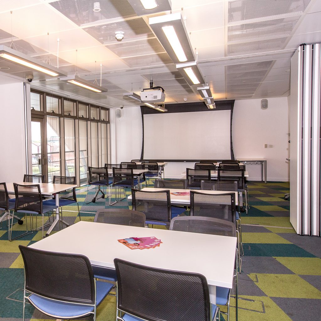 Large meeting room with tables in a classroom style.