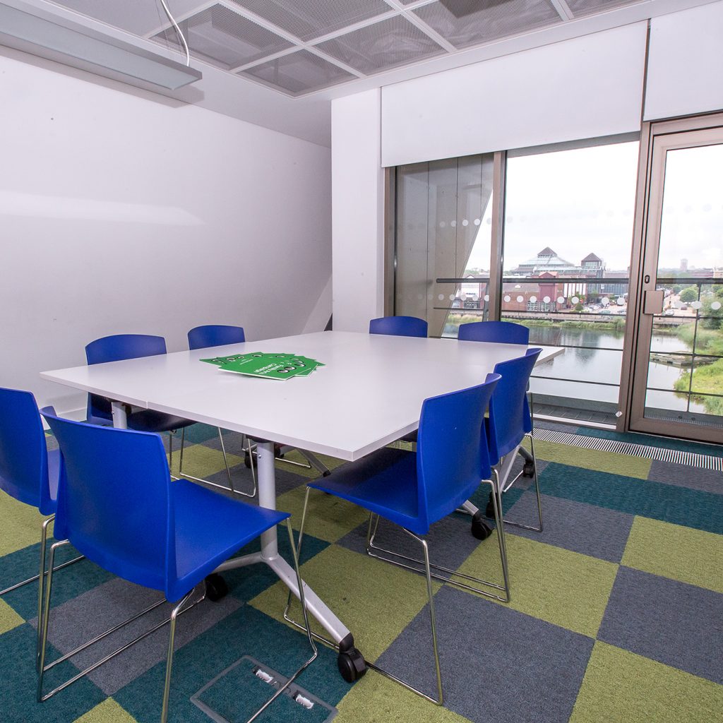 Meeting room set for eight people with view over Canada Water.