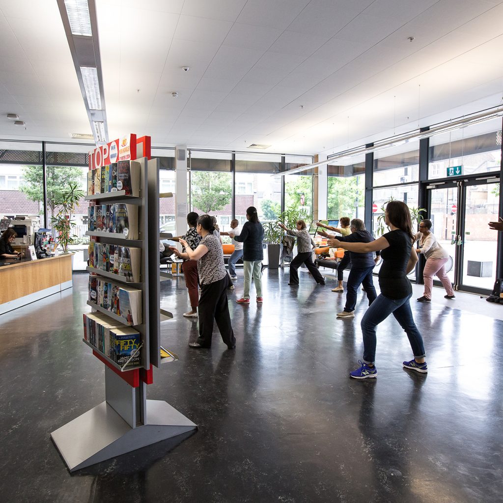 Large, open-plan foyer area in Deptford Lounge with people doing Tai Chi.