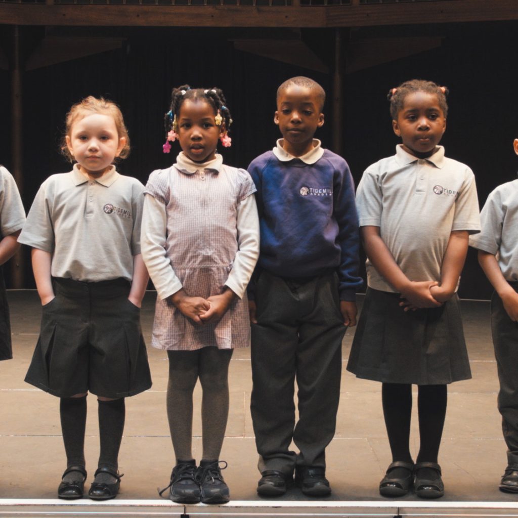 Children holding up postcards to the camera for A Theatre Trip for Every Child