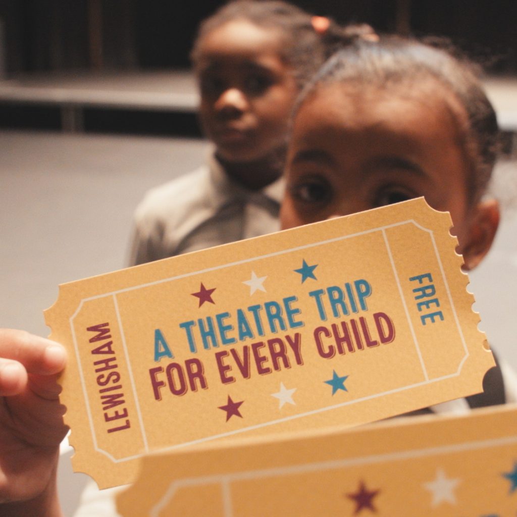 Children holding up postcards to the camera for A Theatre Trip for Every Child