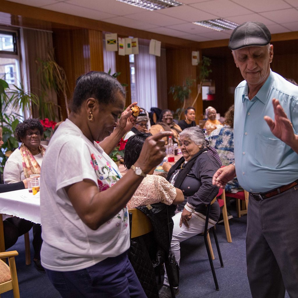 2 people dancing, others look on from a table set for a party