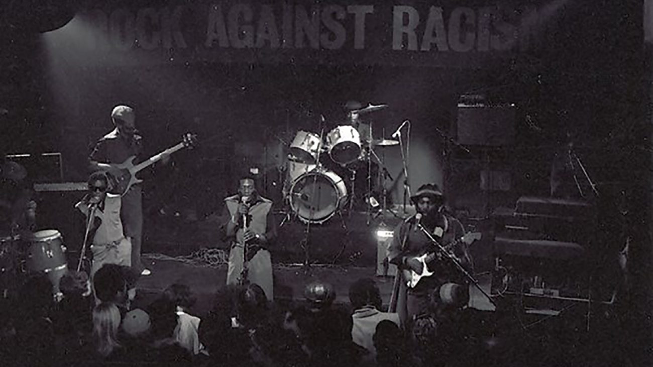 Musicians on stage and the crowd at a Rock Against Racism gig.