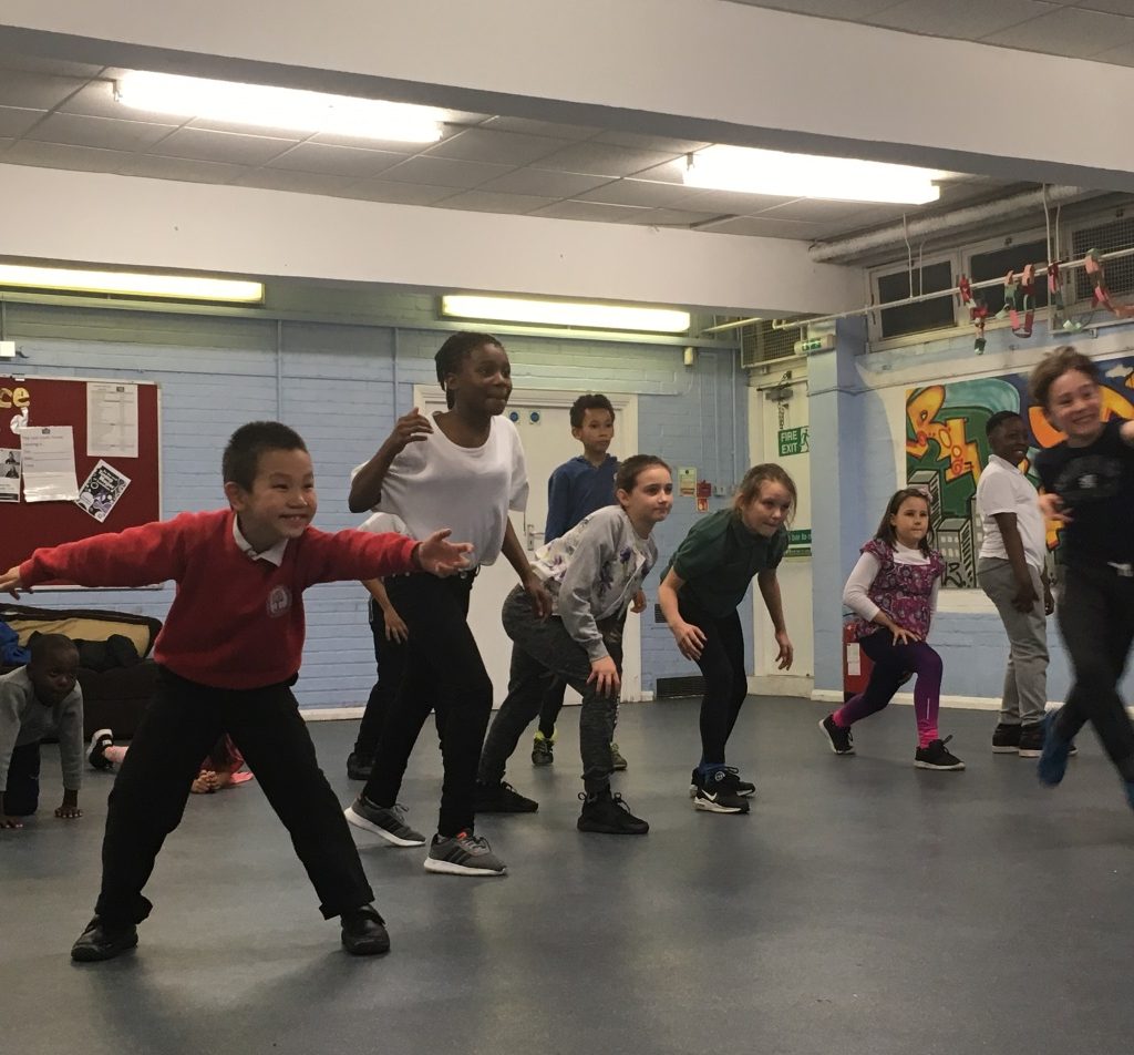 A picture of a group young children smiling and dancing.