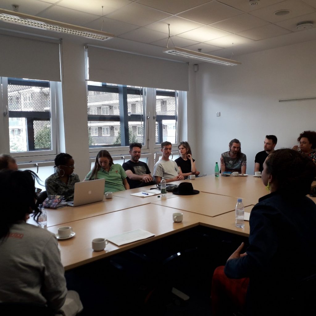 A group of people sitting around a table in a meeting room.