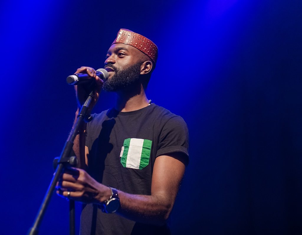 Image of Inua Ellams performing with a microphone
