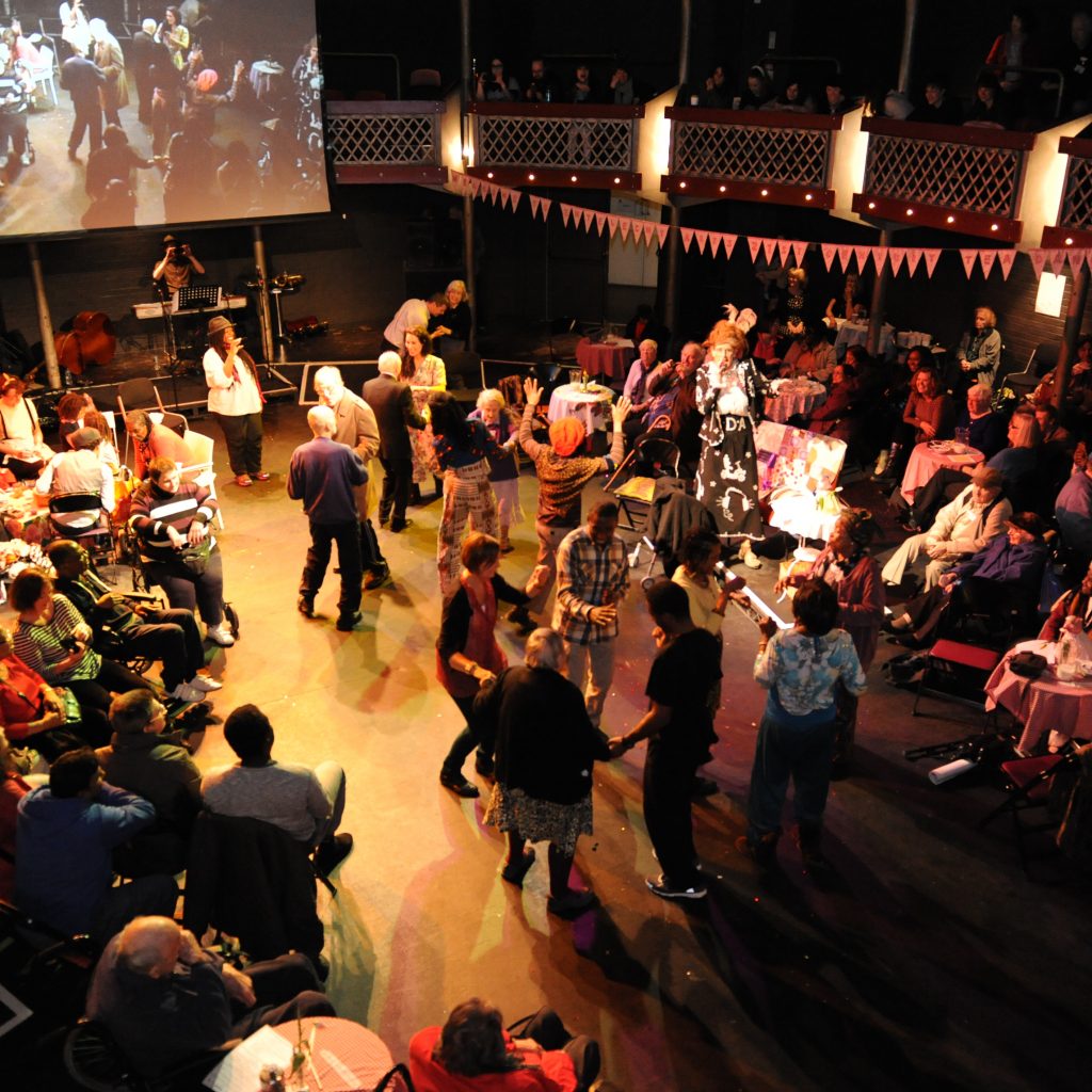 A group of people photographed from above dancing and socliasing