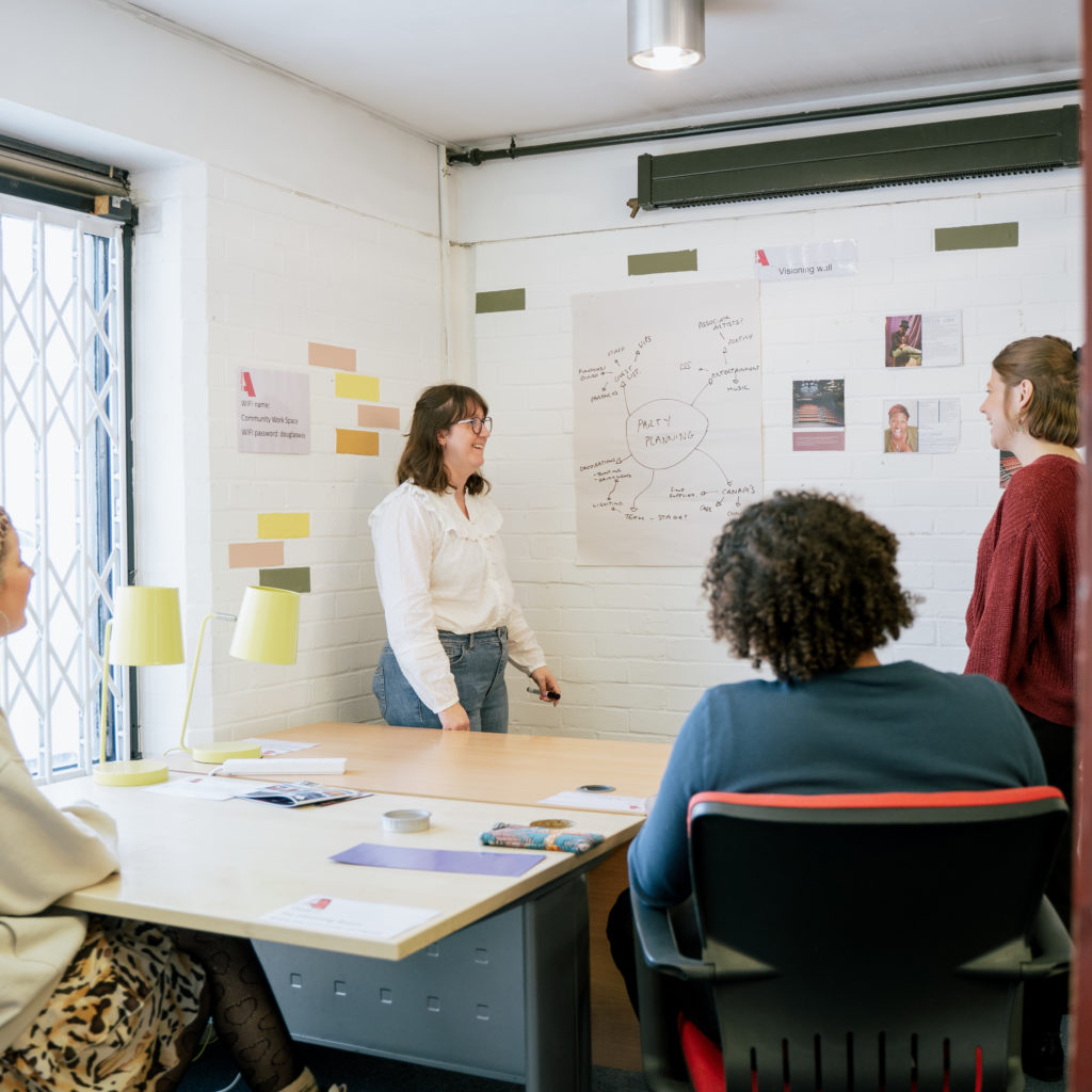 Four people in an Albany meeting room